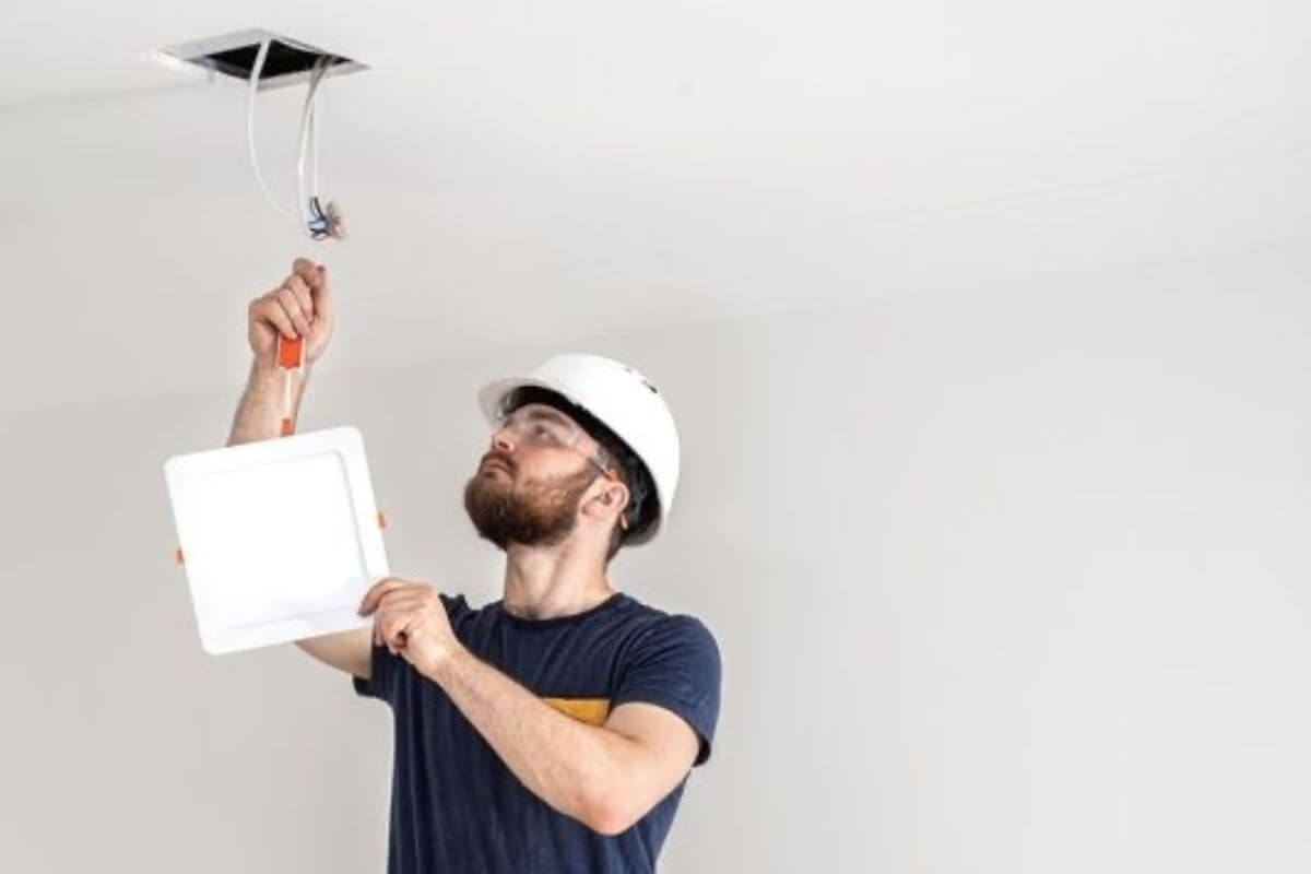 Eletricista realizando reparo residencial